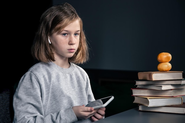 Menina com livros e um telefone nas mãos