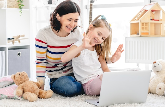 Menina com mãe fazendo videochamada