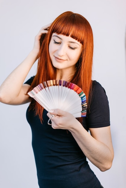 Menina com manicure lindo de verão segurando amostras de cores de unhas. Grande variedade de cores de unhas em um estúdio profissional de unhas.