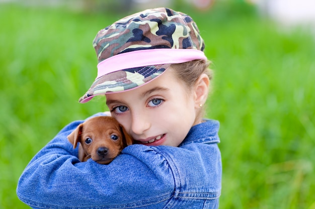 Menina com mascote de cachorrinho de estimação mini pinscher