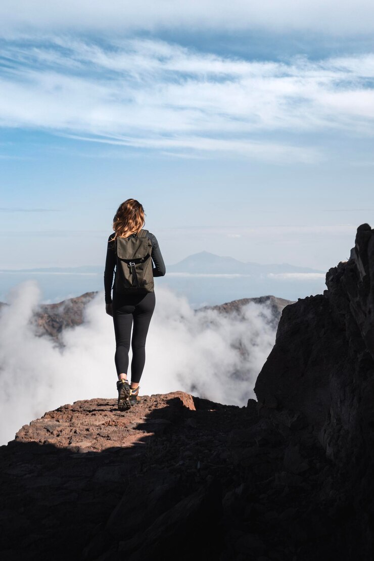 Foto menina com mochila fazendo uma caminhada pela trilha do roque de los muchachos