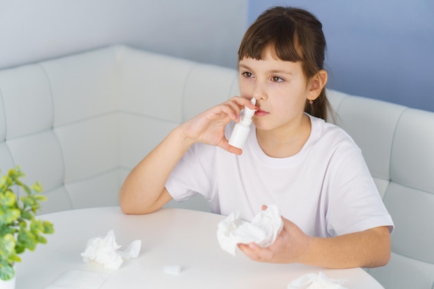 Menina com nariz escorrendo faz irrigações de spray nasal para parar a rinite alérgica e sinusite