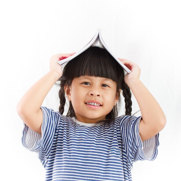 menina com o livro sobre a cabeça no fundo branco.