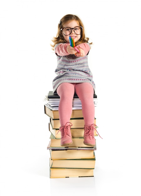 Menina com óculos sentado em livros. de volta à escola