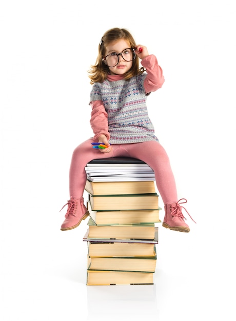 Menina com óculos sentado em livros. de volta à escola