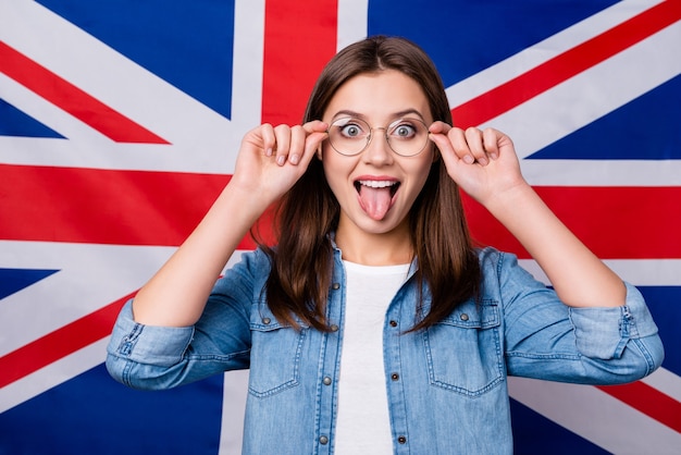 Menina com óculos sobre fundo de bandeira de listras britânicas