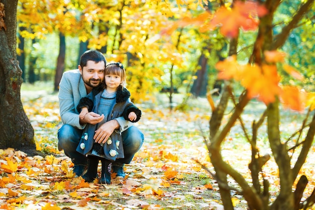 Menina com pai brincando no parque outono.