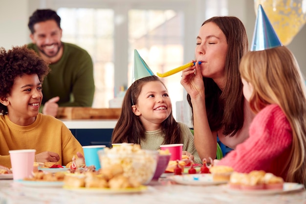 Menina com pais e amigos em casa comemorando aniversário com festa e ventiladores