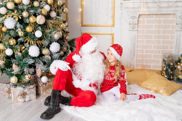 Menina com Papai Noel na árvore de Natal