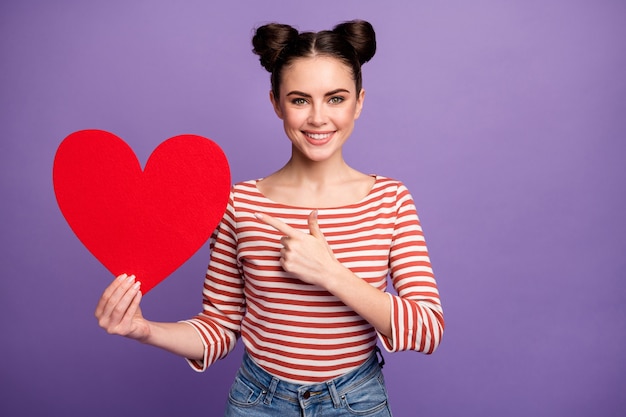 menina com penteado da moda segurando um grande coração