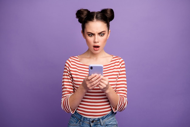 menina com penteado da moda usando telefone isolado em roxo