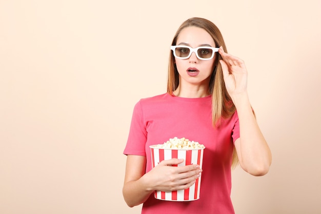 Menina com pipoca em um fundo colorido assistir a um filme d filme