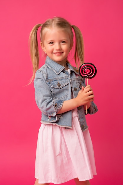 menina com pirulito em fundo rosa