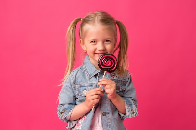 menina com pirulito em fundo rosa