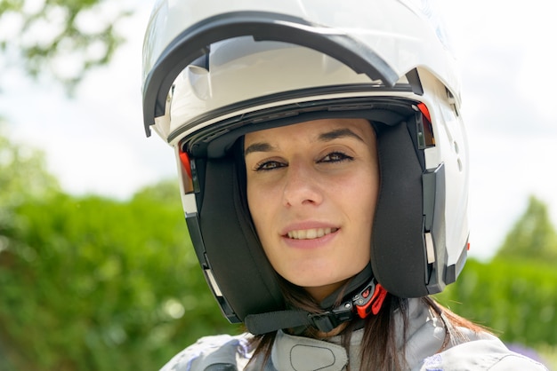 Menina com rosto feliz no capacete branco com uma viseira aberta