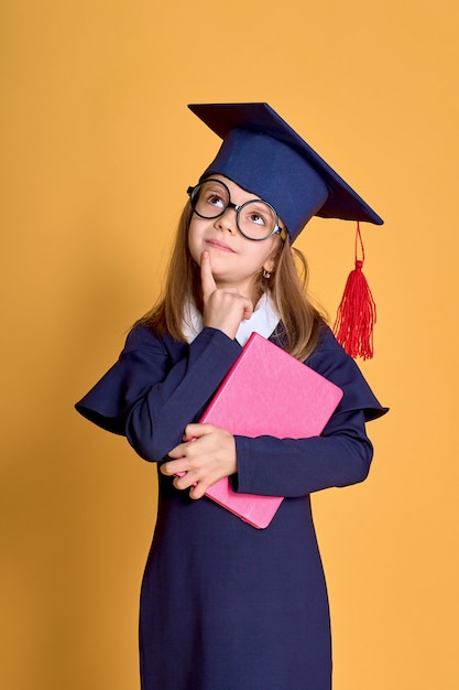 Menina com roupas de acadêmico com livro