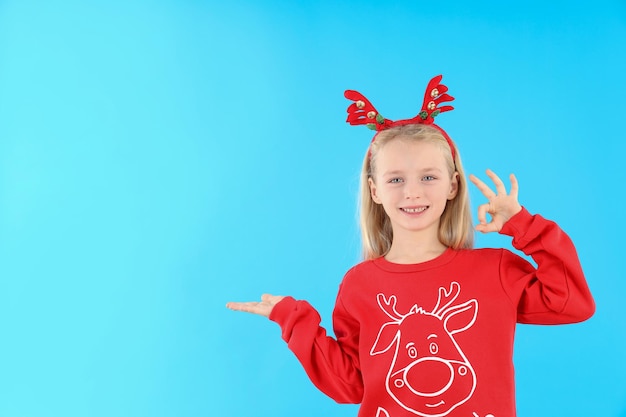 Menina com roupas de Natal em fundo azul