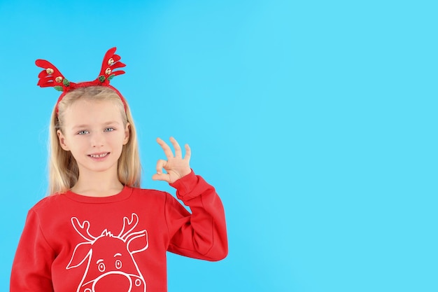 Menina com roupas de Natal em fundo azul