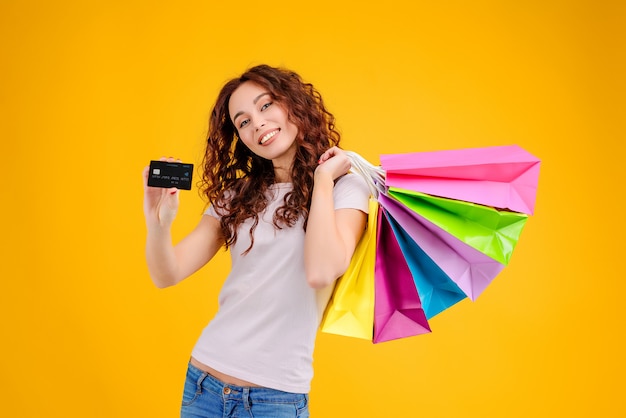 Menina com sacos de compras e cartão de crédito isolado