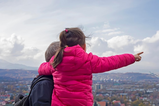 Menina com seu pai olhando para as vistas da cidade de Almaty no Cazaquistão