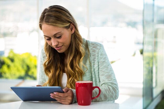 Menina com seu tablet sorrindo em casa