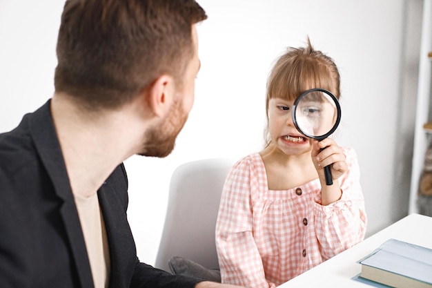 Menina com síndrome de Down estudando com seu professor em casa