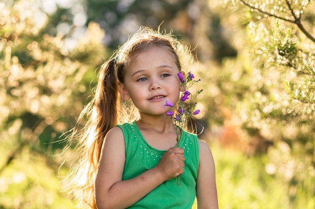 menina com sinos de flores na natureza no verão