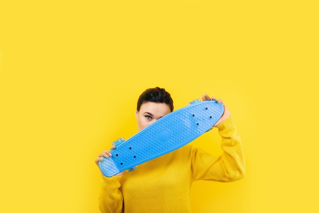 Menina com skate no espaço amarelo