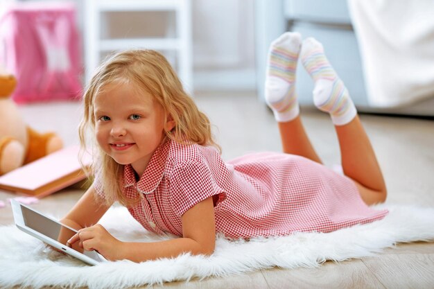 Menina com tablet no quarto