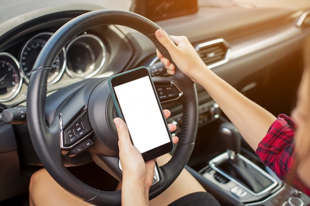 Menina com telefone inteligente no carro