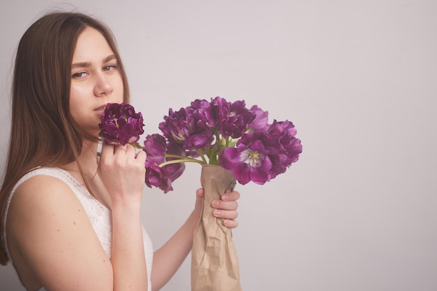 Menina com tulipas em um fundo branco