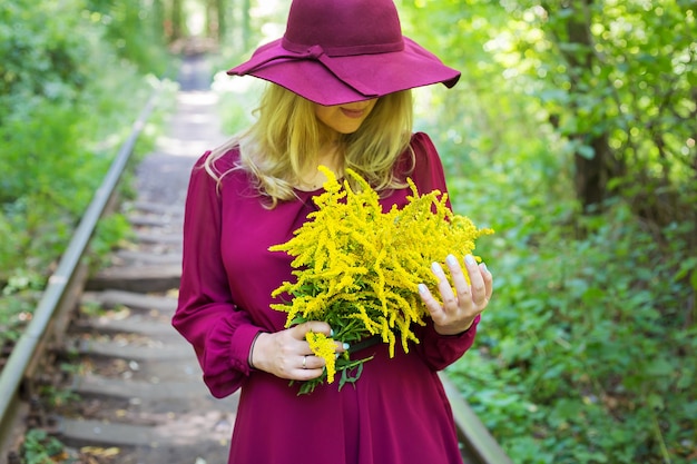 Menina com um buquê de flores amarelas