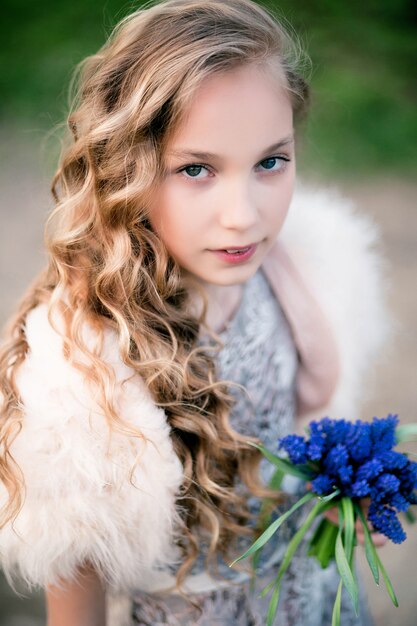 menina com um buquê de flores azuis