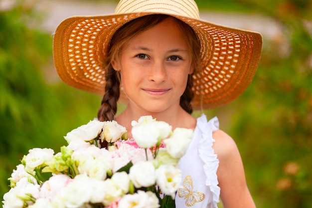 Menina com um buquê de flores brancas. Dia de verão.