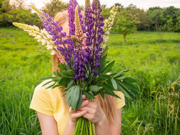 Menina com um buquê de flores brilhantes na mão.