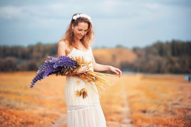 Menina com um buquê de flores no outono