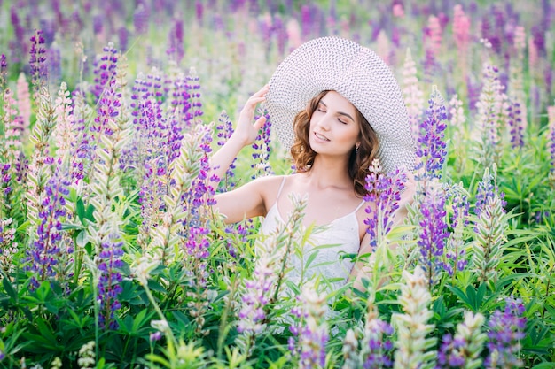 Menina com um buquê de tremoço no campo