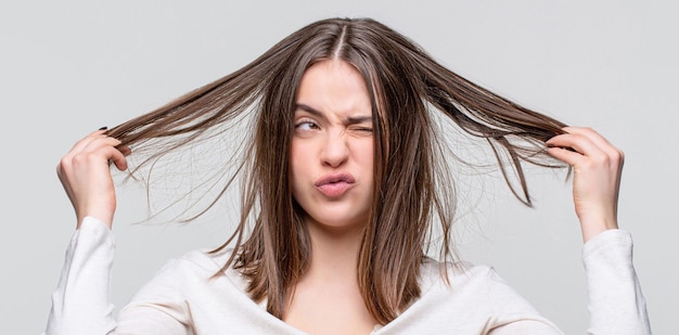 Menina com um cabelo ruim. Dia dos cabelos ruins. Mulher frustrada com um cabelo ruim. Mulher com o cabelo ruim, o cabelo dela está bagunçado e emaranhado