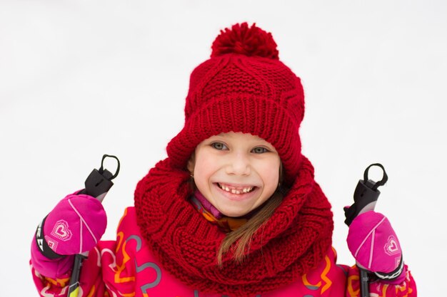 Foto menina com um chapéu de lã vermelha em winter park