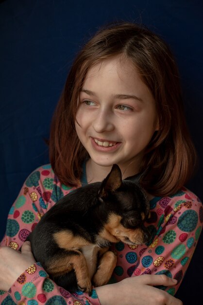 Menina com um chihuahua. Menina segurando chihuahua. Menina com seu animal de estimação nos braços.