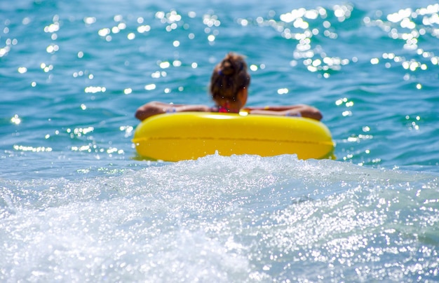 Menina com um círculo no mar foto desfocada