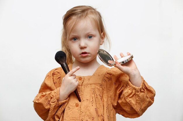 menina com um espelho e um pincel em um fundo branco