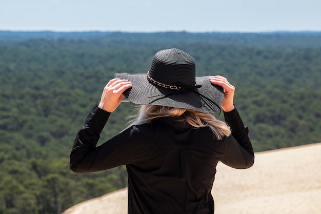 Menina com um grande chapéu na natureza