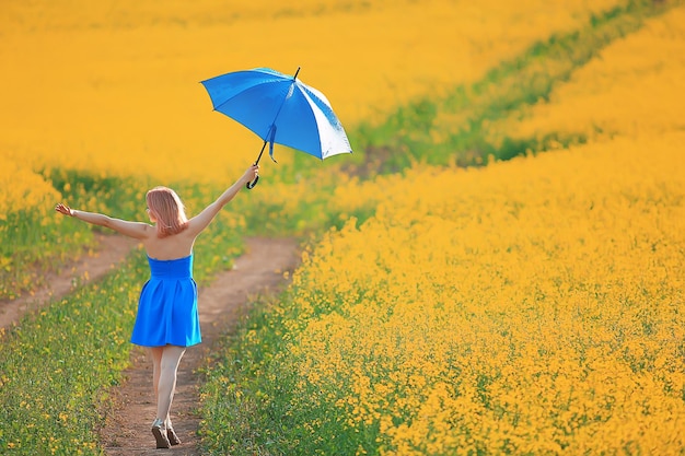 menina com um guarda-chuva em um campo de flores de verão, campo amarelo de natureza feminina do país