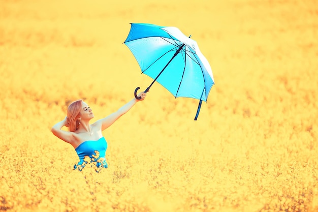 menina com um guarda-chuva em um campo de flores de verão, campo amarelo de natureza feminina do país