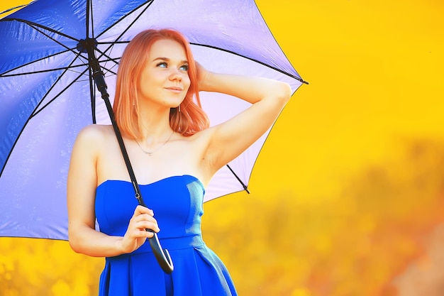 menina com um guarda-chuva em um campo de flores de verão, campo amarelo de natureza feminina do país