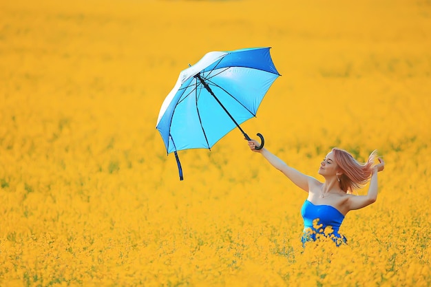 menina com um guarda-chuva em um campo de flores de verão, campo amarelo de natureza feminina do país