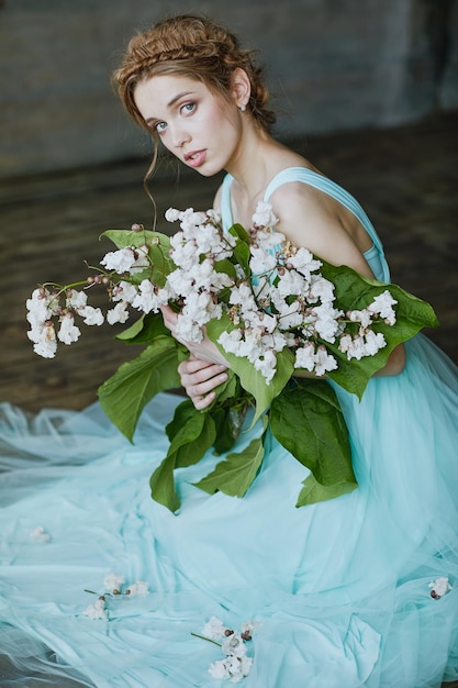 Menina com um lindo buquê de flores em um vestido azul