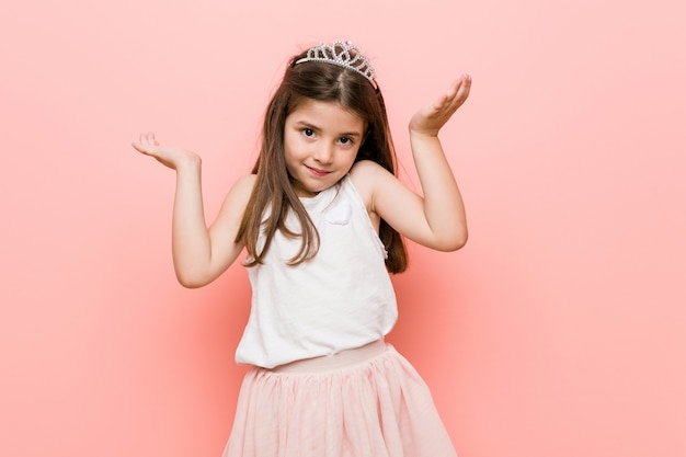 Menina com um olhar de princesa faz escala com os braços, sente-se feliz e confiante