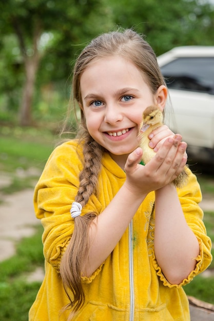 Menina com um patinho de primavera